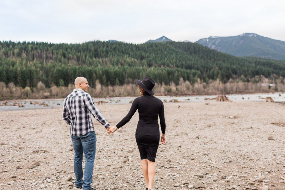 Two people walk hand in hand across the gravel at Rattlesnake Lake