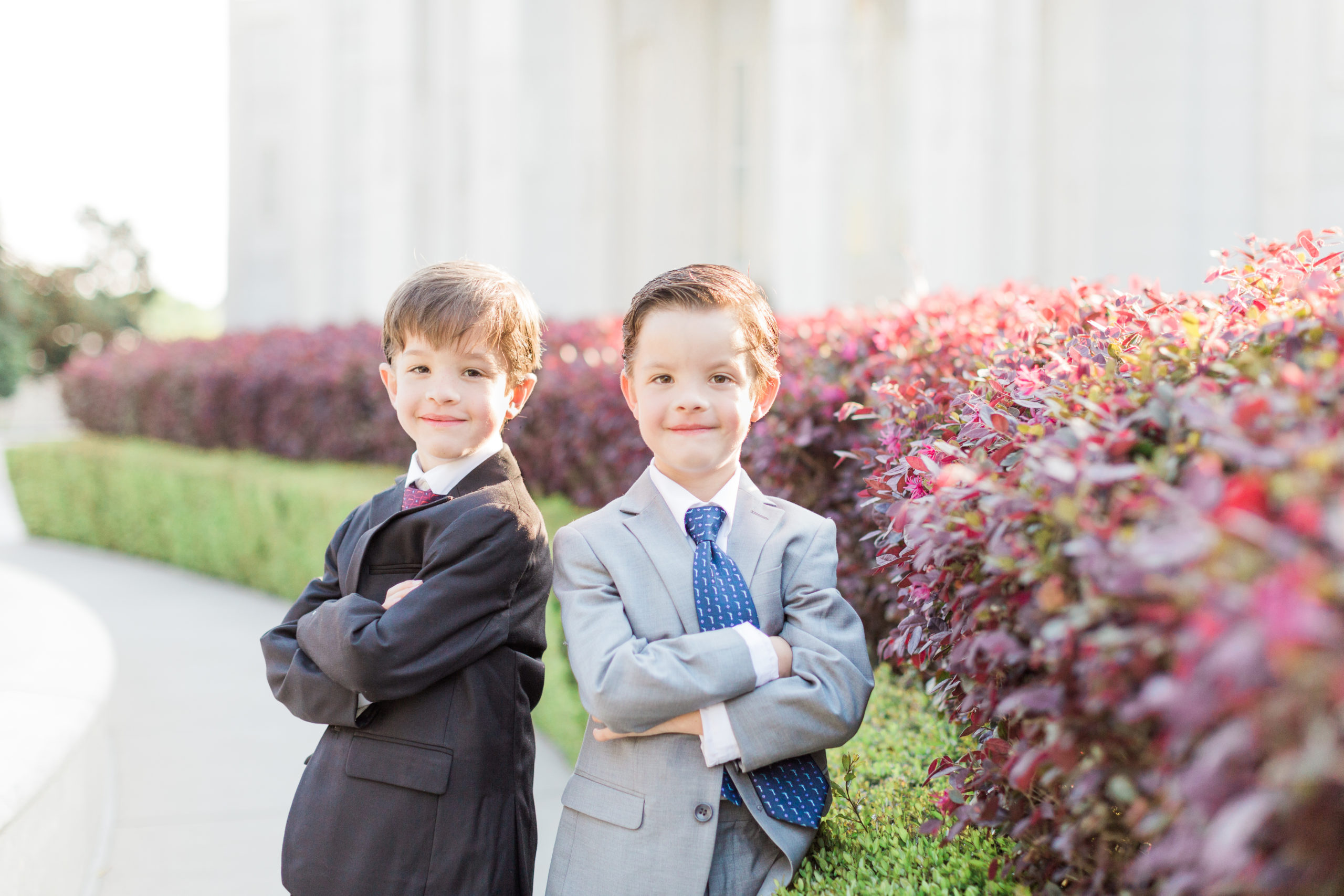 Two young men fold their arms as they pose for photos