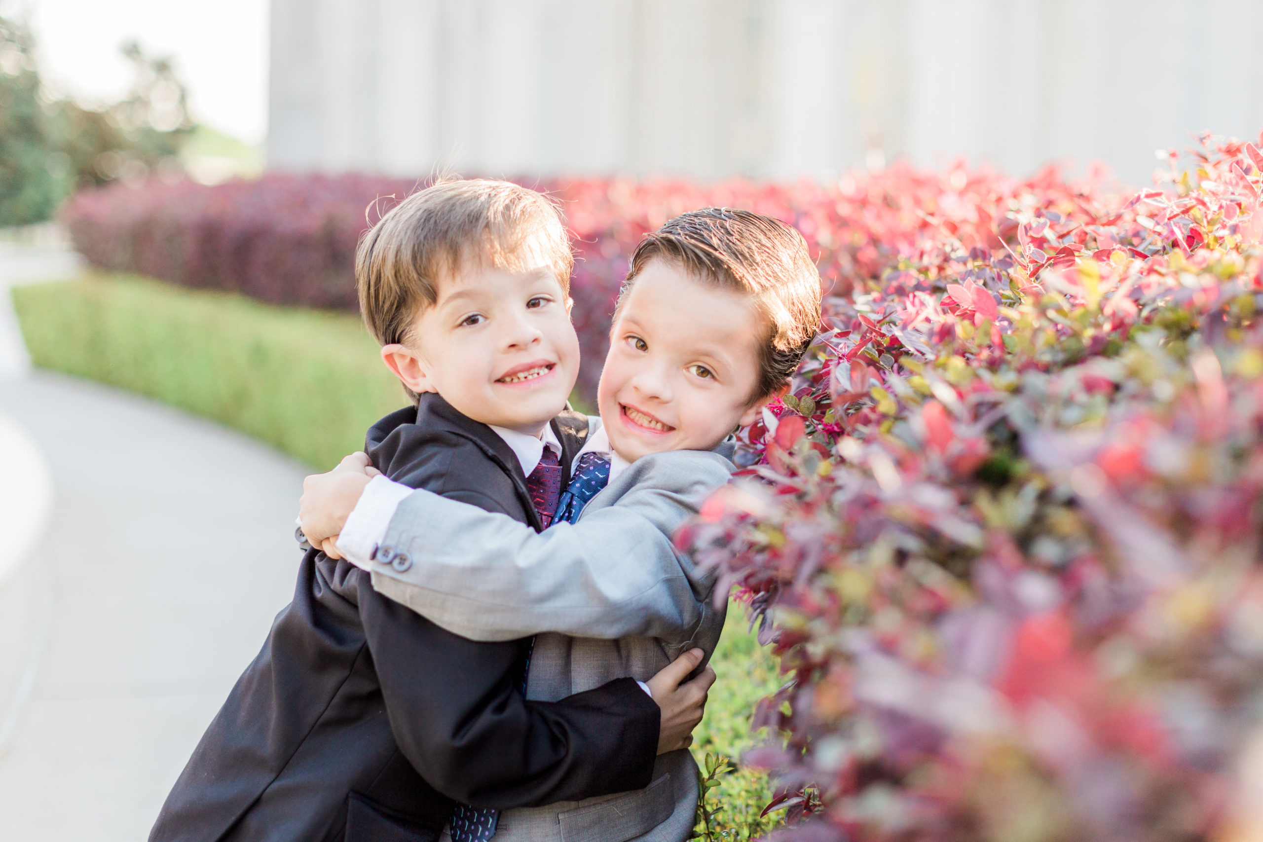 Two brothers wrap their arms around each other and smile for the camera