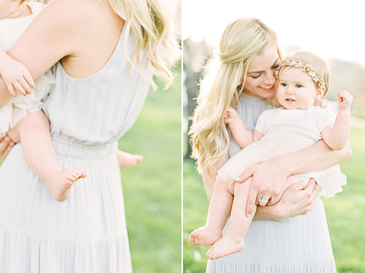 Mom snuggles into her daughter whos wearing a white dress