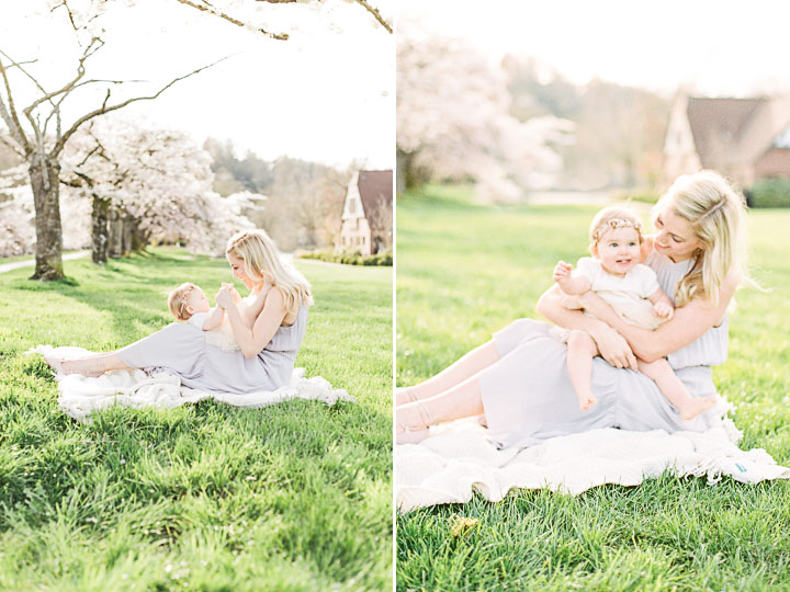A mother and daughter play together on a white blanket