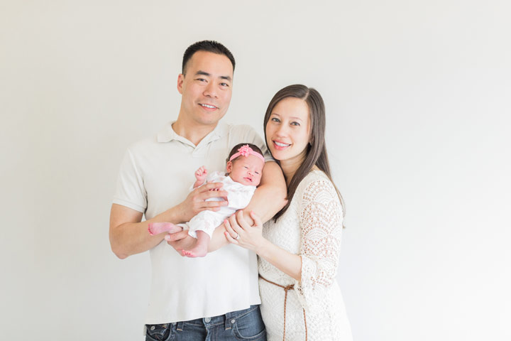 A family with a newborn daughter pose during their photo session in Frisco Texas