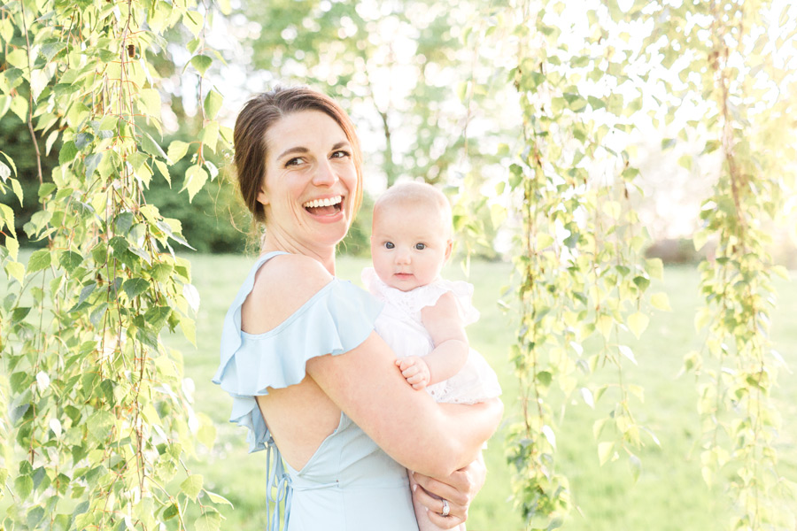 A Mom laughs joyfully as she holds her baby in her arms