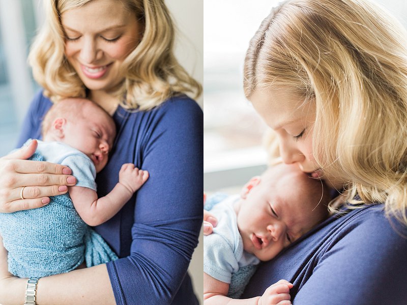 A new Mom in a blue dress snuggles with her tiny newborn son