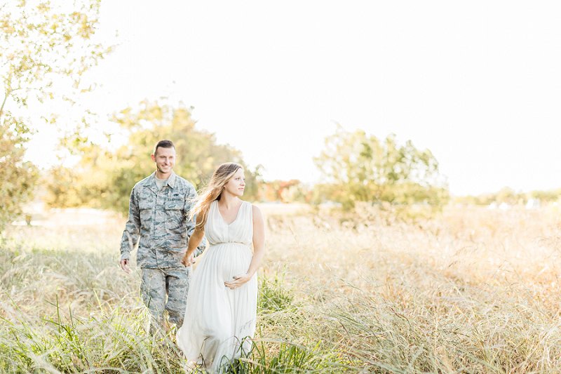 Two soon to be parents walk through a field in Dallas during their maternity session