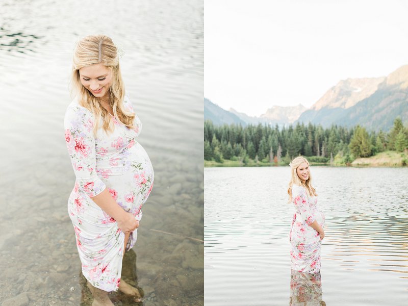 A fun loving pregnant Mama stands in the gorgeous blue lake and holds her dress