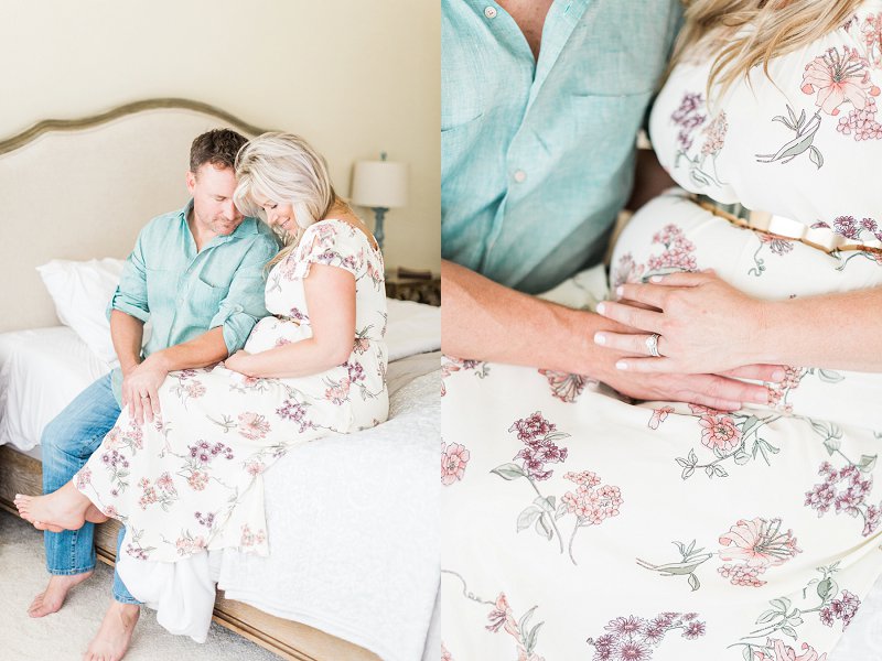 A married couple sit together on the edge of their bed and pose for their Dallas Maternity Photography session