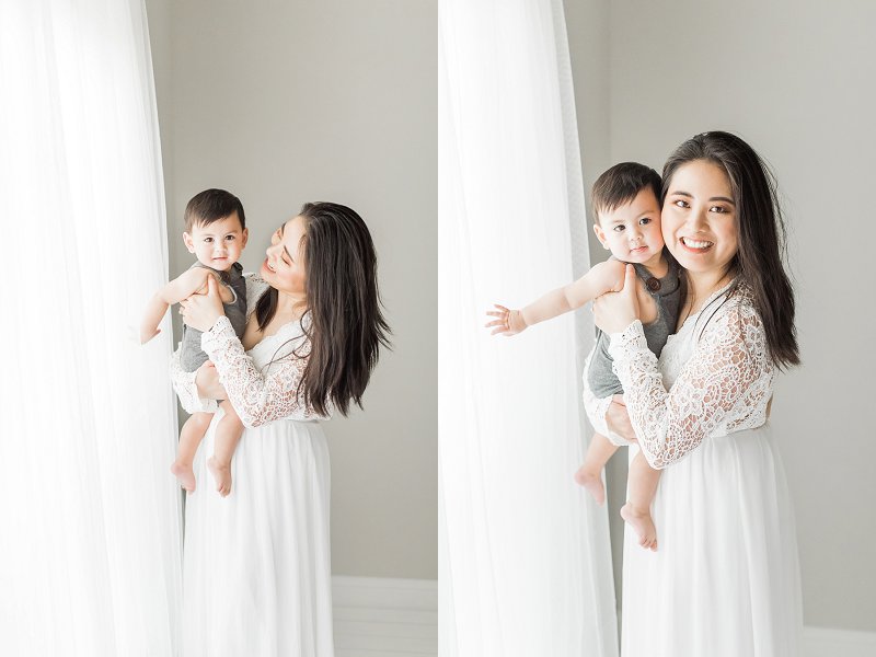 A gorgeous young mother wearing a flowing white dress holds her son close and smiles at him