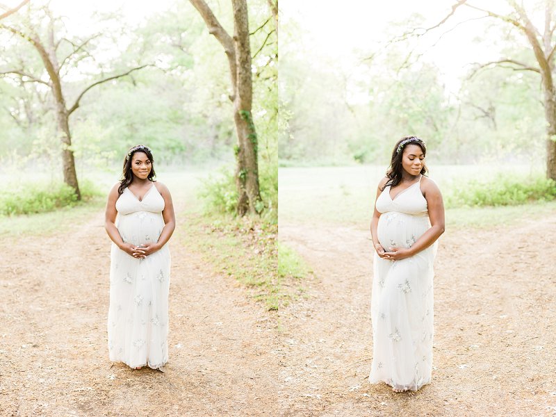 A bohemian styled Mother cradles her arms around her baby bump and softly smiles