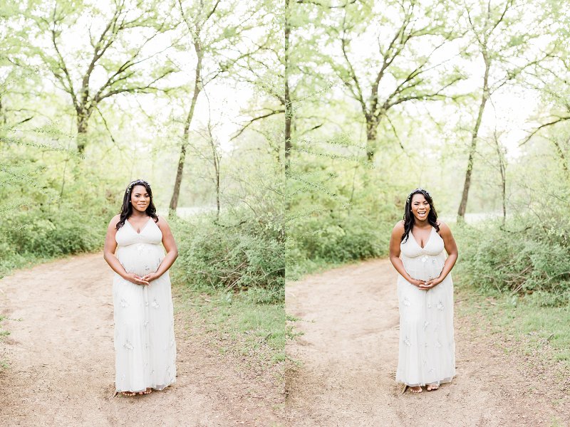 A woman stands in the middle of a dirt road holding her pregnant bump and laughs out loud