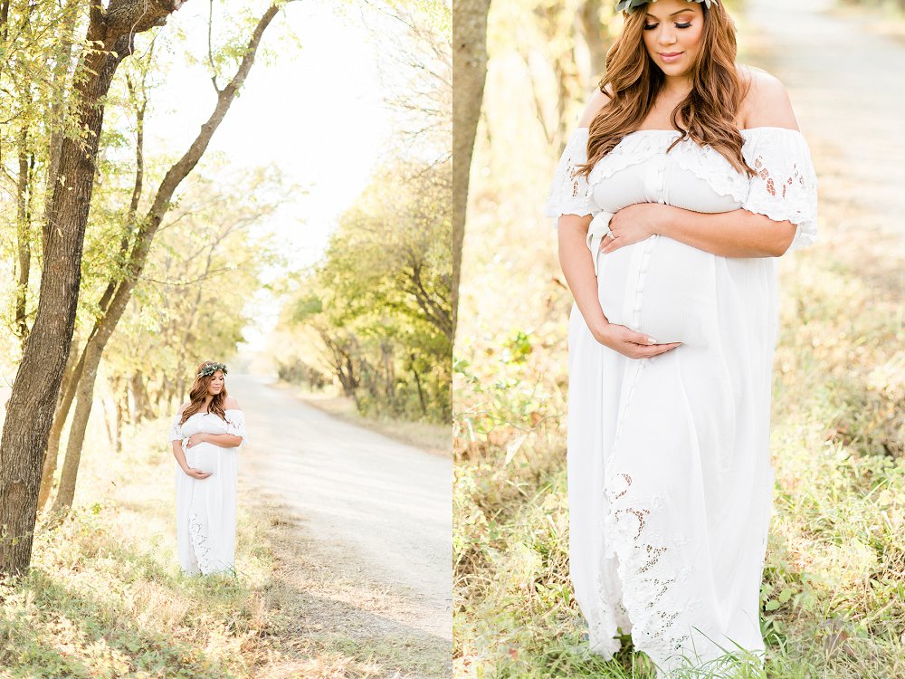 A close up detail photo of a womans arms wrapped around her baby bump with the golden light shining through the trees behind her