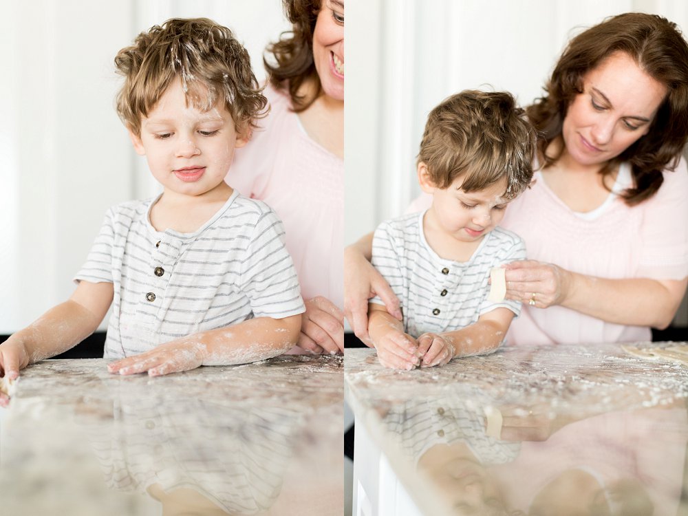 The little boy stands close by his Grandma as she helps him make part of the pie together