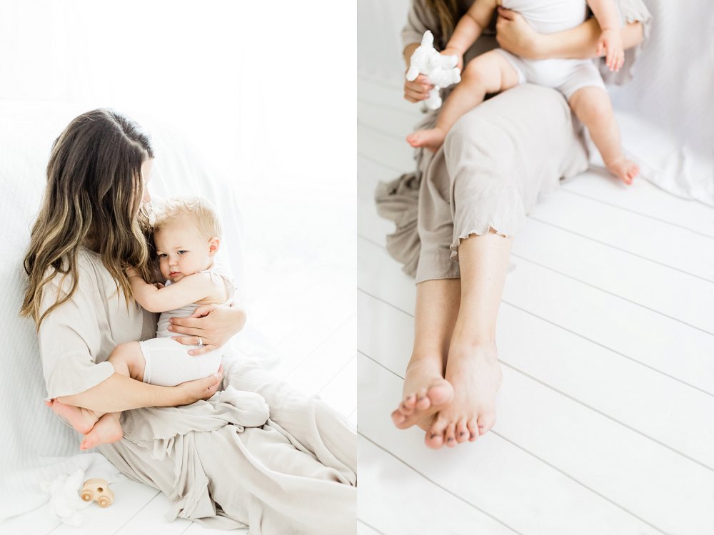 A detail photo of Mom and babys legs as they play together on the white floors