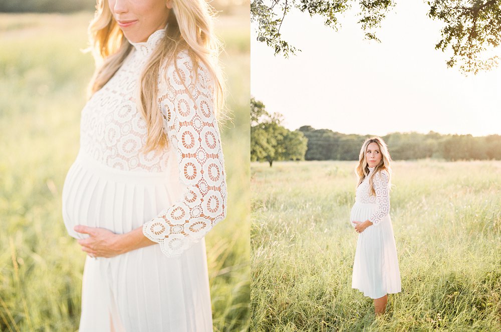 The second time expectant Mother poses in a field with both hands cradling her growing bump
