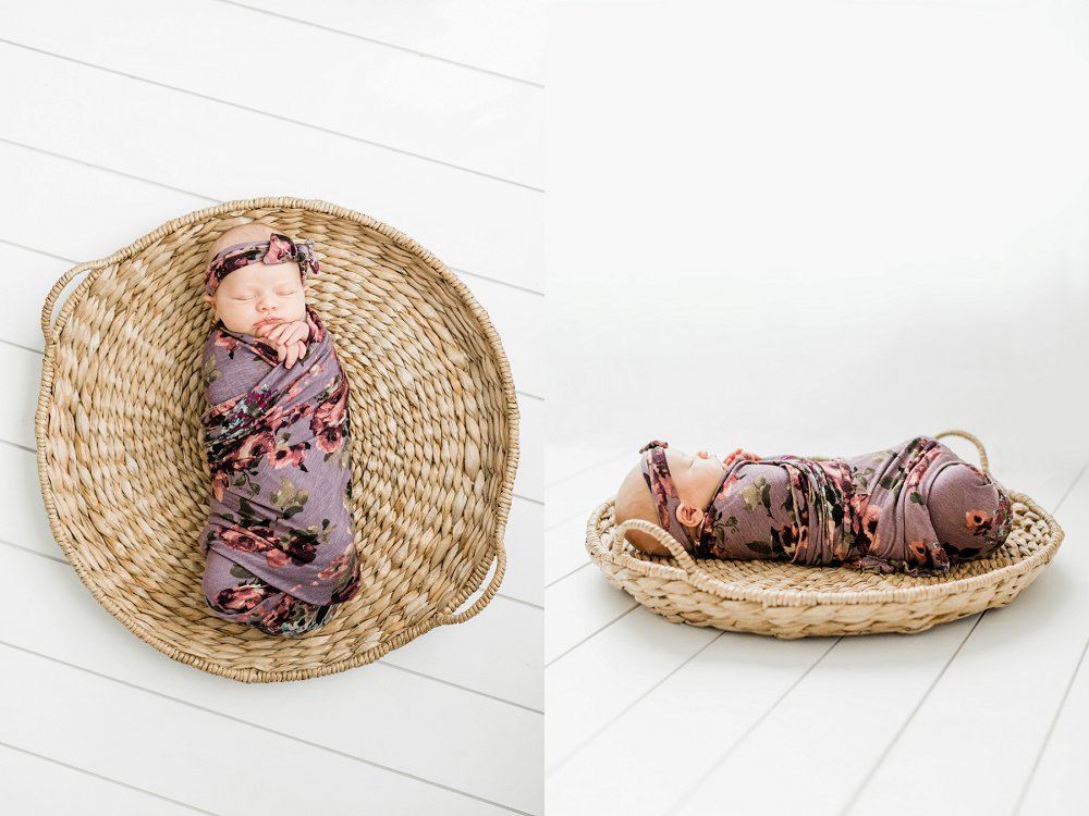 Newborn baby girl wrapped in a floral swaddle inside a basket
