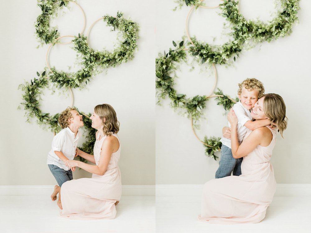 Motherhood in blush dress hugging and laughing with son
