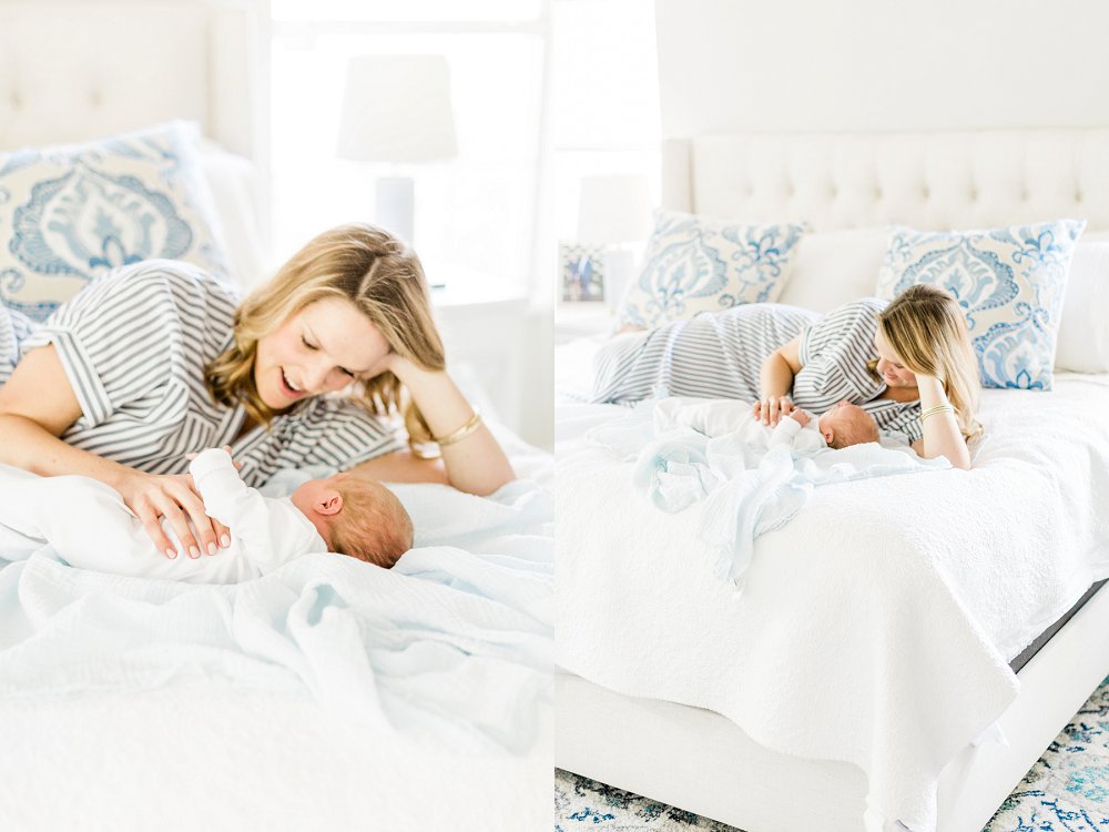 Mom and newborn son lay on bed together as she smiles and talks to him