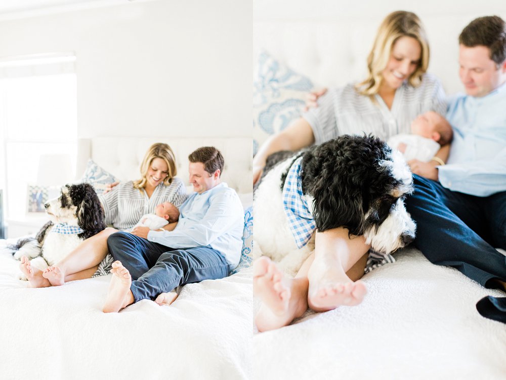 Dad, Mom, newborn baby boy, and family dog relax and sit together on gorgeous white bed