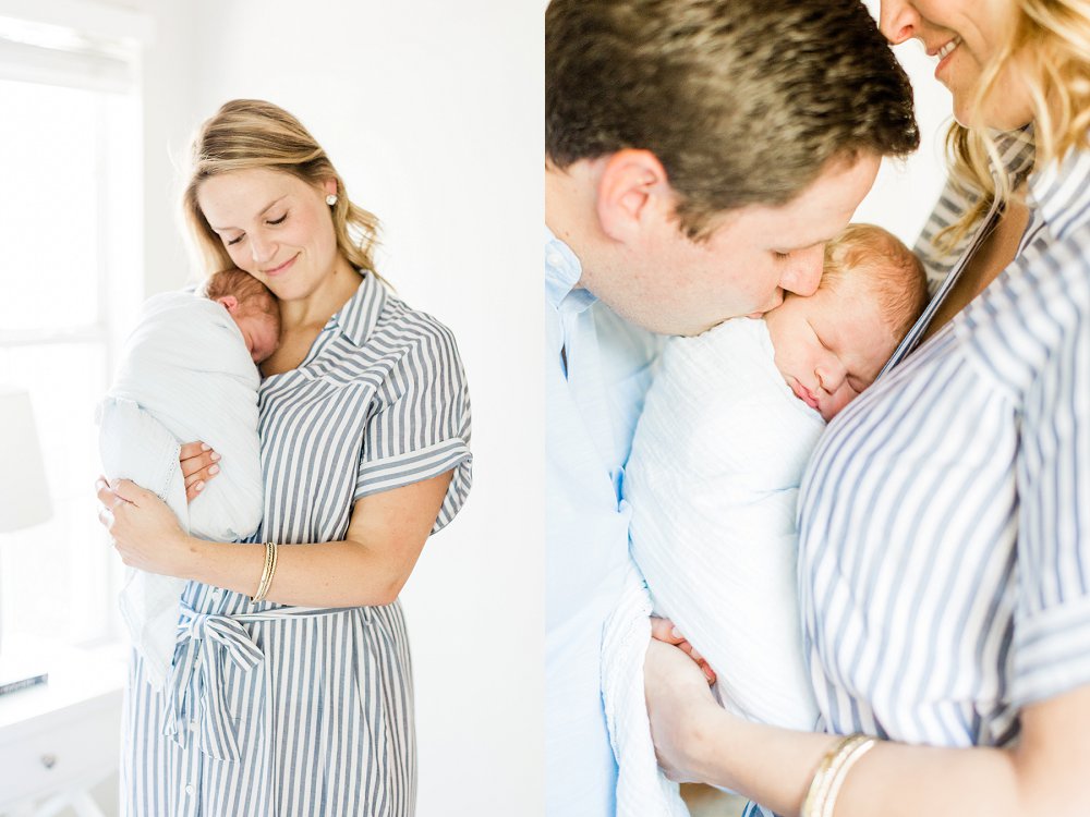 Mom holds newborn son and smiles while Dad kisses his cheek
