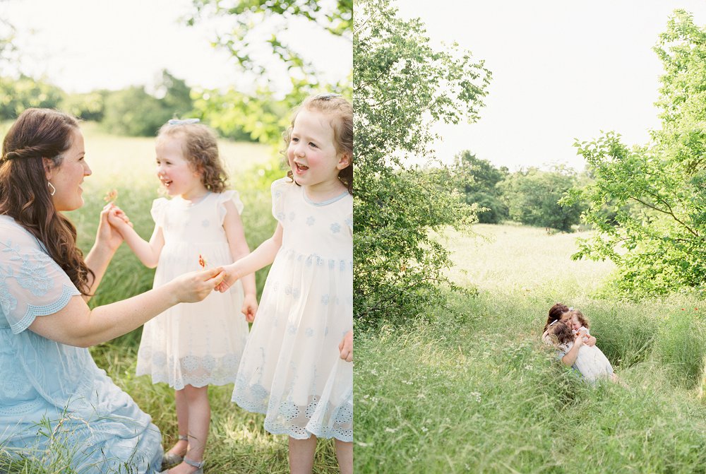 Twin girls wearing flowy cream and blue dresses smile at their mother while they hand her a flower
