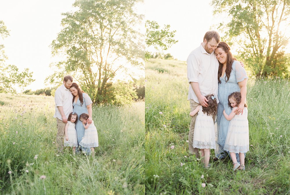 A young family poses together in the tall grass for their Plano Family Photographer